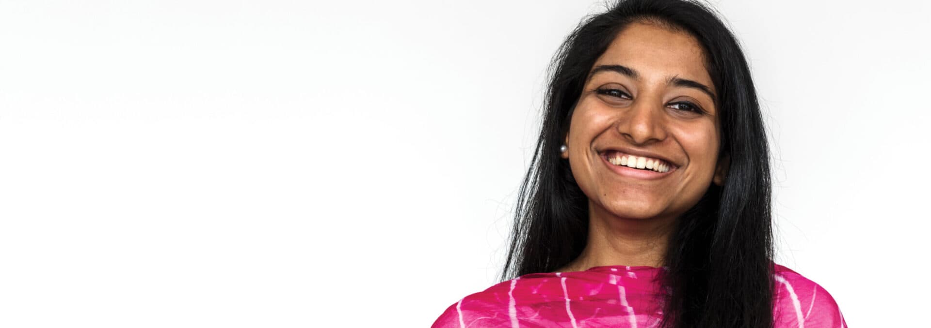 A woman in a sari smiles at the camera